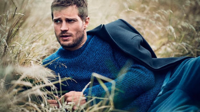 Man in blue sweater lying in tall grass
