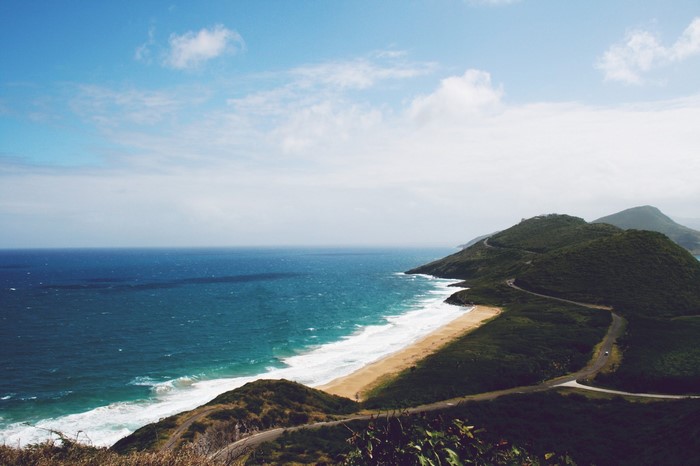 Coastal road winding through green hills overlooking the ocean