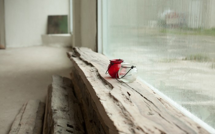 Two glass candle holders on a wooden plank