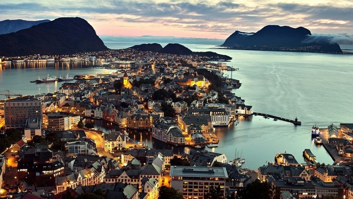 Alesund, Norway cityscape at dusk with mountains and sea