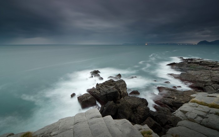 Rocky coast with waves under a cloudy sky