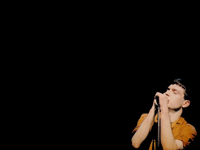 Ian Curtis of Joy Division performing on stage