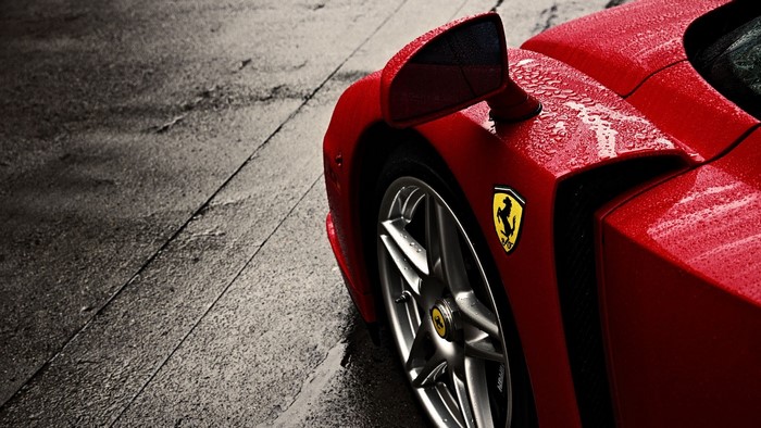 Red Ferrari Enzo with water droplets on a wet surface