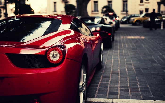 Red Ferrari 458 parked on cobblestone street