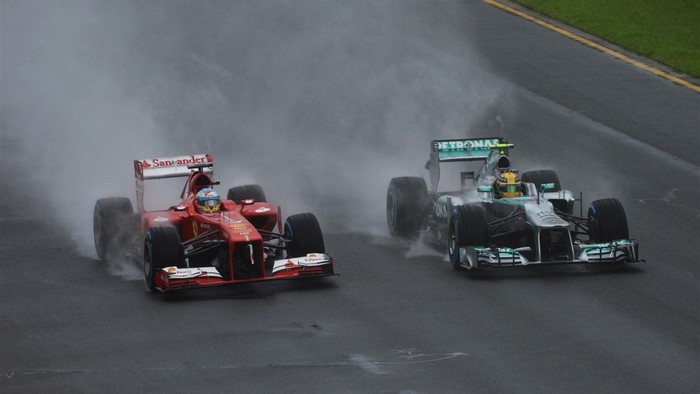 Fernando Alonso in Ferrari and Lewis Hamilton in Mercedes racing in the rain