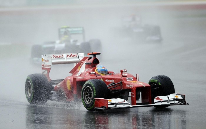 Fernando Alonso driving a Ferrari Formula 1 car in the rain