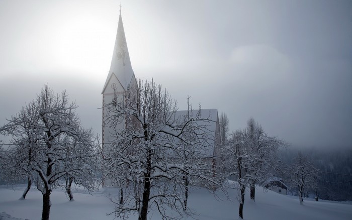Snowy winter morning with a church and trees