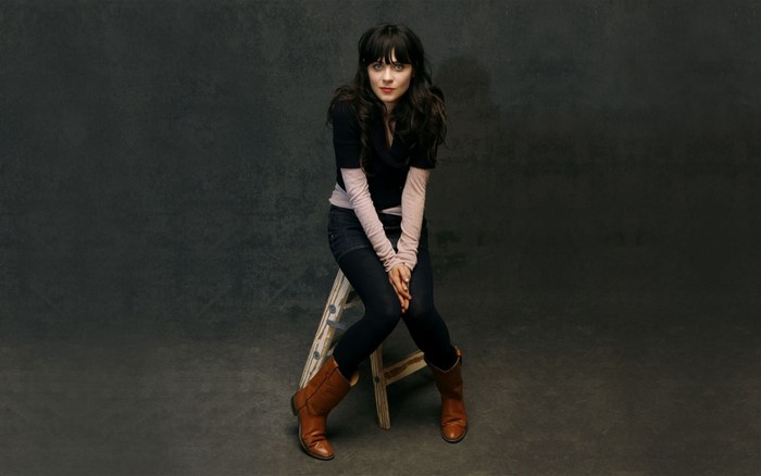 Zooey Deschanel sitting on a stool