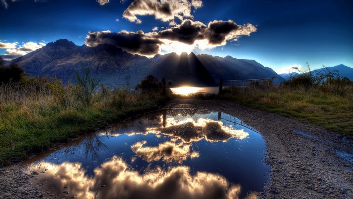 Sunlight over mountains and lake reflection