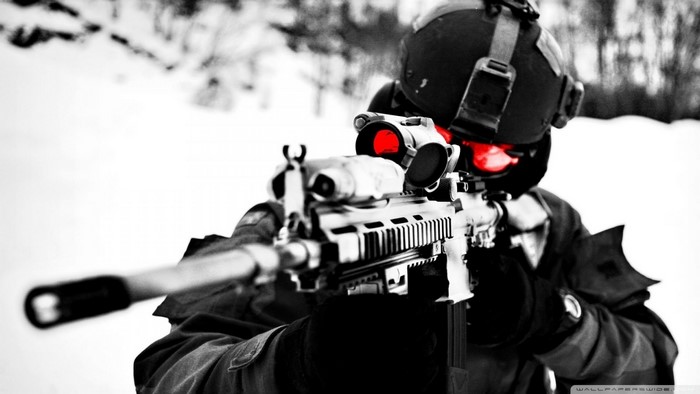 Soldier aiming a rifle with red-tinted scope
