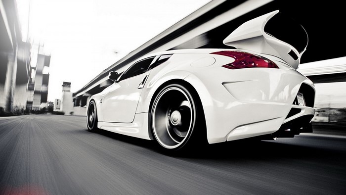 White Nissan 370Z sports car with large spoiler in motion