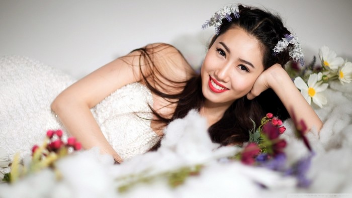 Asian woman in a white gown with flowers