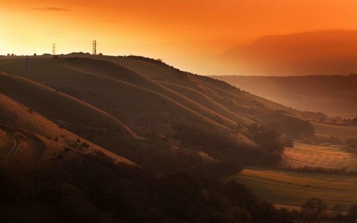 Rolling hills at sunset with radio towers