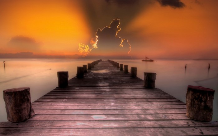 Wooden pier at sunset with boat