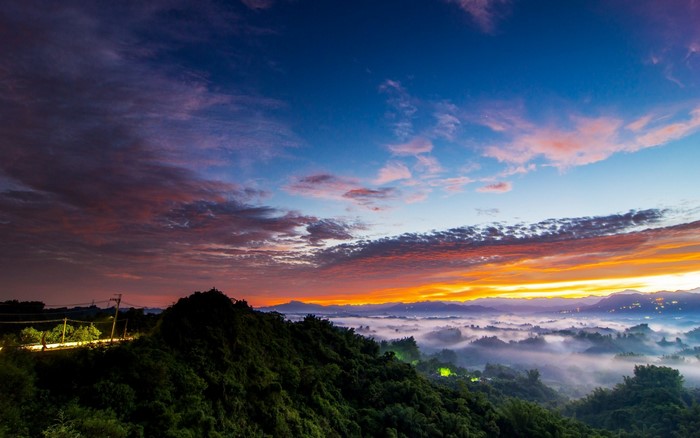 Mountain landscape with fog and colorful sunset sky
