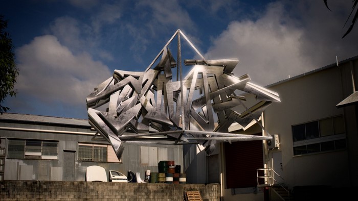 Graffiti sculpture in front of industrial buildings