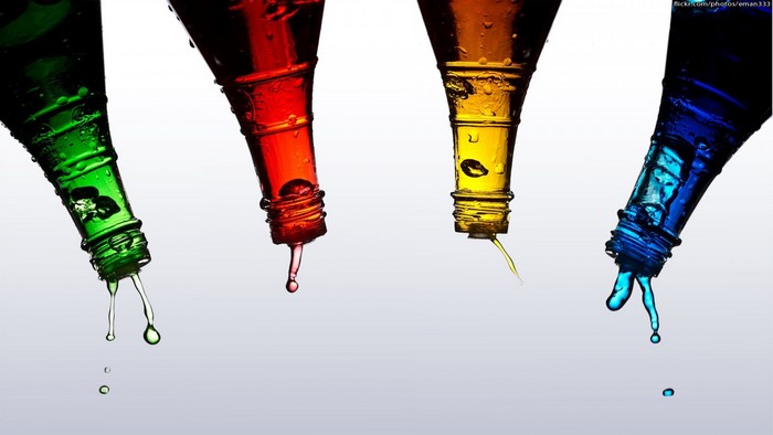Four colored bottles pouring liquid