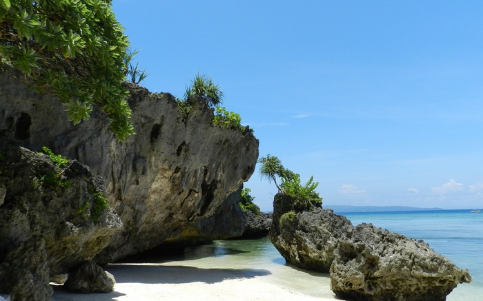 Rocky beach with clear blue water and sky