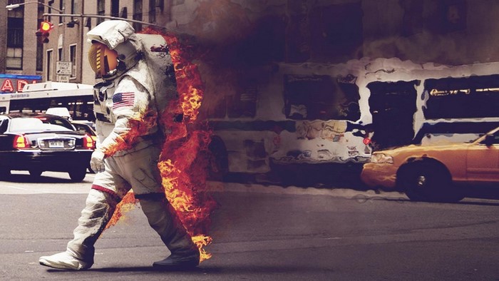 Astronaut on fire crossing a city street