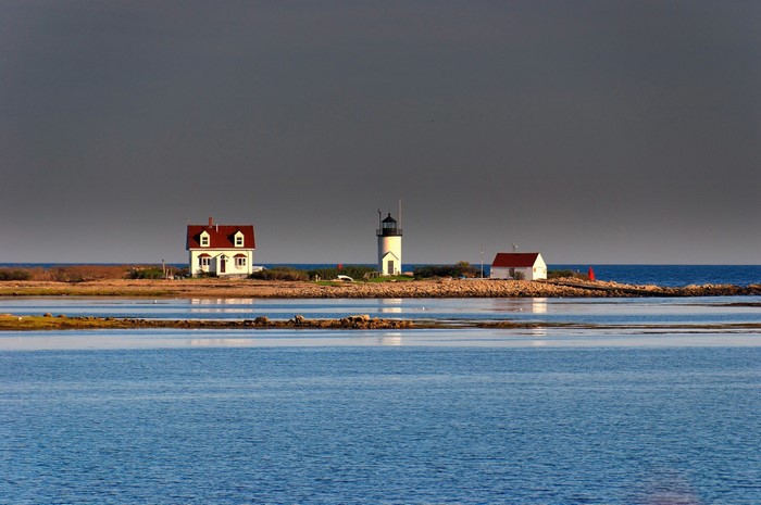 Lighthouse and houses on a rocky island in the sea