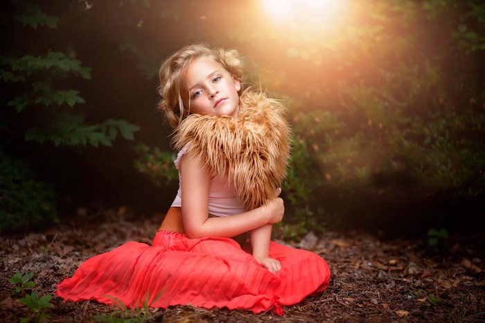 Girl in red skirt and fur collar in forest