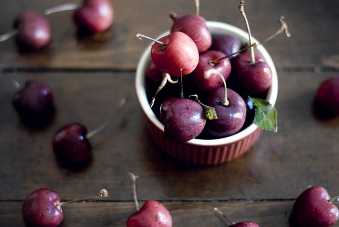 Cherries in a bowl on a wooden surface
