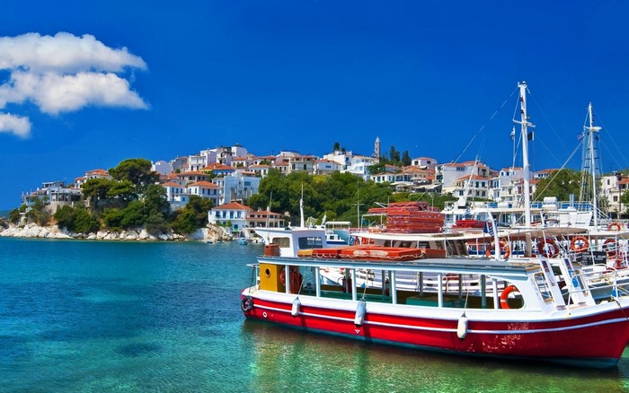 Boats in a harbor with a Greek town in the background