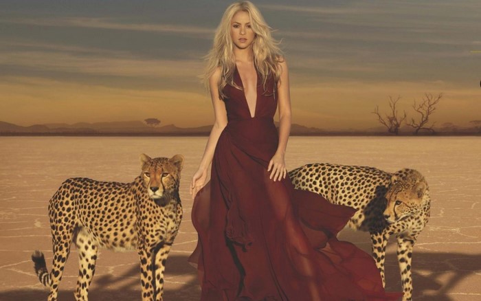 Shakira with cheetahs in a desert landscape