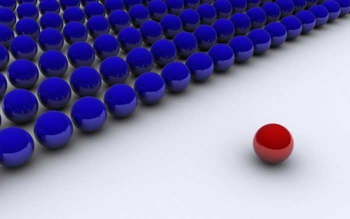 A single red ball stands out from a group of blue balls