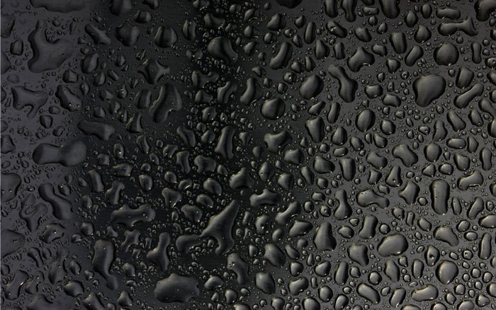 Water droplets on a black textured surface