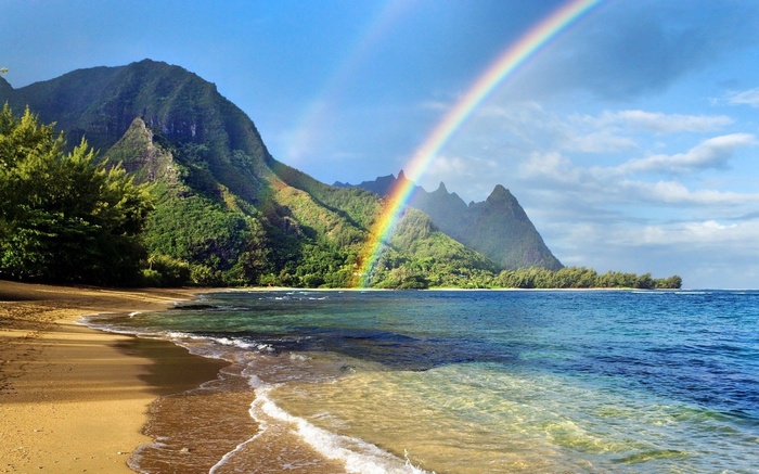 Beach with mountains and rainbow