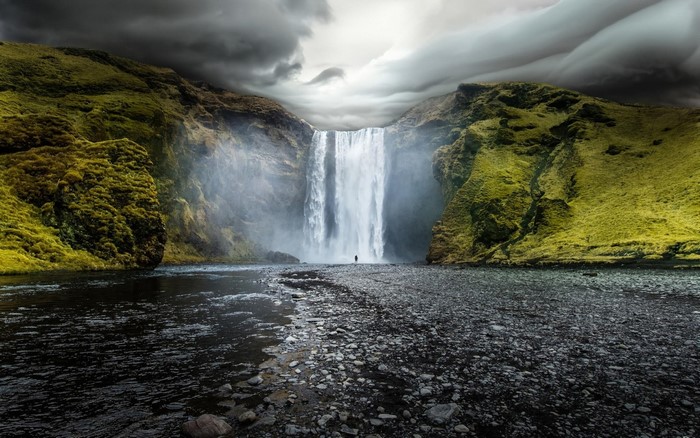 Skogafoss Waterfall in Iceland with a lone figure