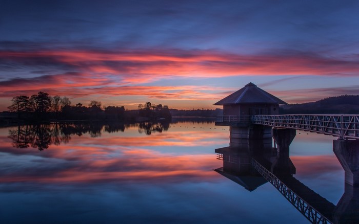 Sunset over a calm lake with a water tower