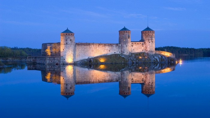 Olavinlinna Castle reflected in water at dusk