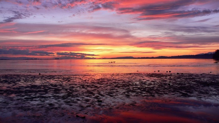 Sunset over the ocean with colorful clouds and reflections