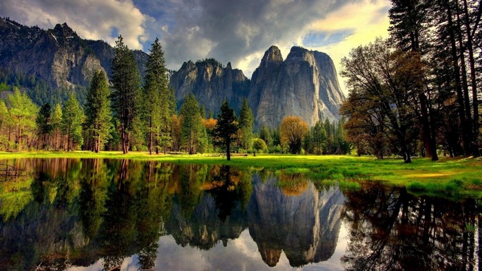 Mountains reflected in a calm lake with trees