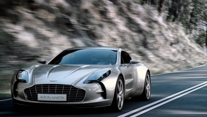 Silver Aston Martin One-77 driving on a winding road