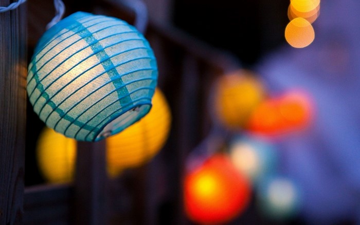 String of colorful paper lanterns with bokeh effect