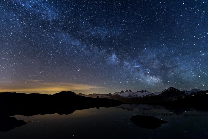 Milky Way galaxy over mountains and lake at night