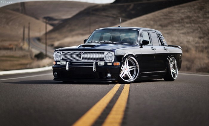 Black modified GAZ Volga sedan on a road