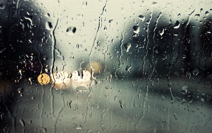 Raindrops on a window with blurred lights