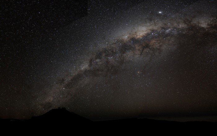 Milky Way galaxy over a dark mountain silhouette