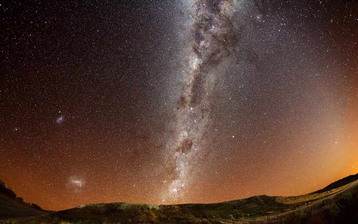 The Milky Way galaxy over a dark landscape
