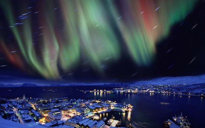 Aurora Borealis over a coastal town at night