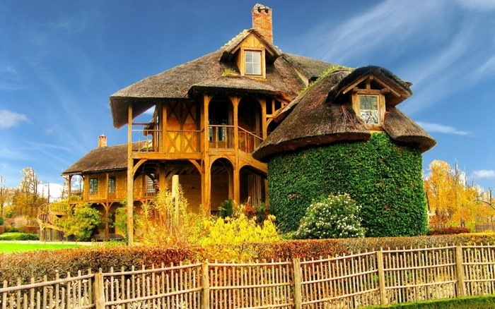 Thatched roof wooden house in autumn landscape