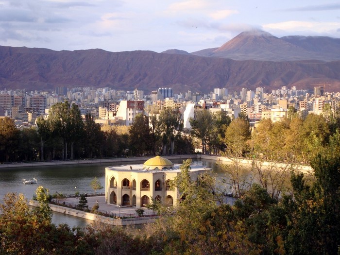 Palace on a lake with city and mountains in background