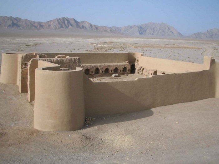 Ancient ruins in a desert landscape with mountains in the background