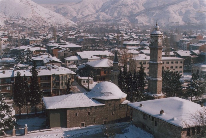 Cityscape with mosque and clock tower in winter snow, Tokat, Turkey