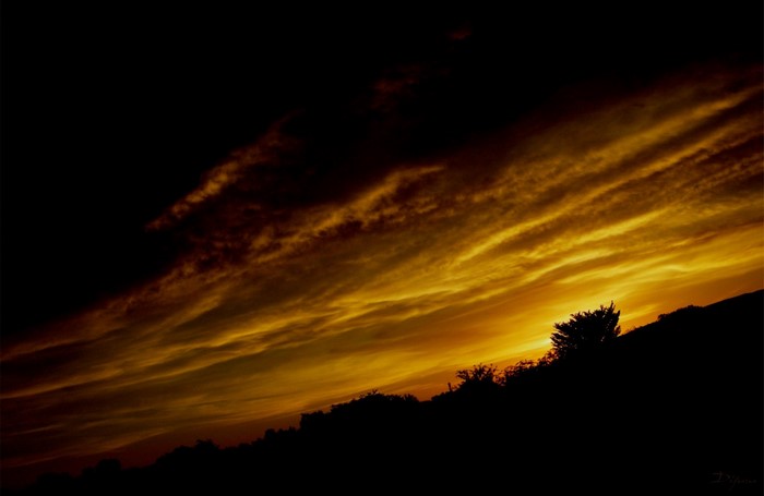 Sunset with dramatic clouds over silhouetted hills