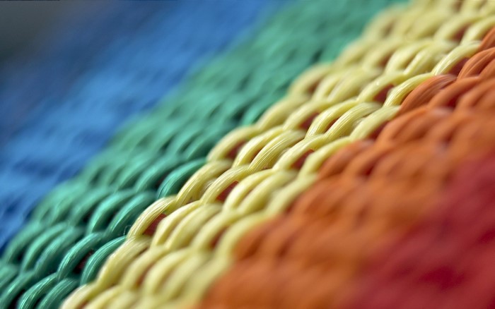 Close-up of colorful woven fabric with blue, green, yellow, and orange threads